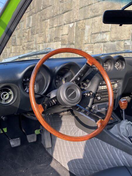 Dieses Foto zeigt das Lenkrad und einen Teil des Innenraums eines Datsun 240Z. Ein wahrer Hidden Classic abseits des Mainstreams.