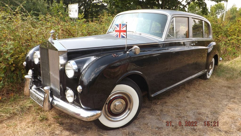Dieses Foto zeigt den Rolls-Royce Phantom V einen Oldtimer aus dem Jahr 1962, der aktuell bei My Next Classic zum Verkauf angeboten wird. Sie finden hier einen rechtsgelenkten Klassiker aus prominenten Vorbesitz, mit H-Kennzeichen, der zugelassen und in einem guten Allgemeinzustand ist. Bieten Sie mit!