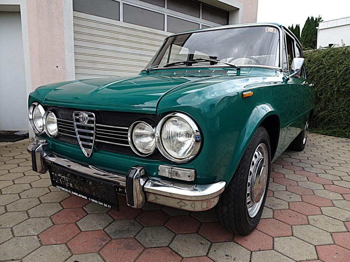 Dieses Foto zeigt den Alfa Romeo Giulia 1300 Ti, einen Oldtimer von 1969. Das Fahrzeug wurde bereits aufwändig restauriert und befindet sich in einem top Zustand. Es hat eine österreichische Zulassung und TÜV. Der 1290-cm³-Motor mit 60 kW lässt die leichte Giulia deutlich temperamentvoller wirken, als man es erwartet. Optisch begeistert dieser Klassiker mit einer selten schönen Kombination: grüne Außenfarbe und braune Lederausstattung. Bieten Sie jetzt mit!